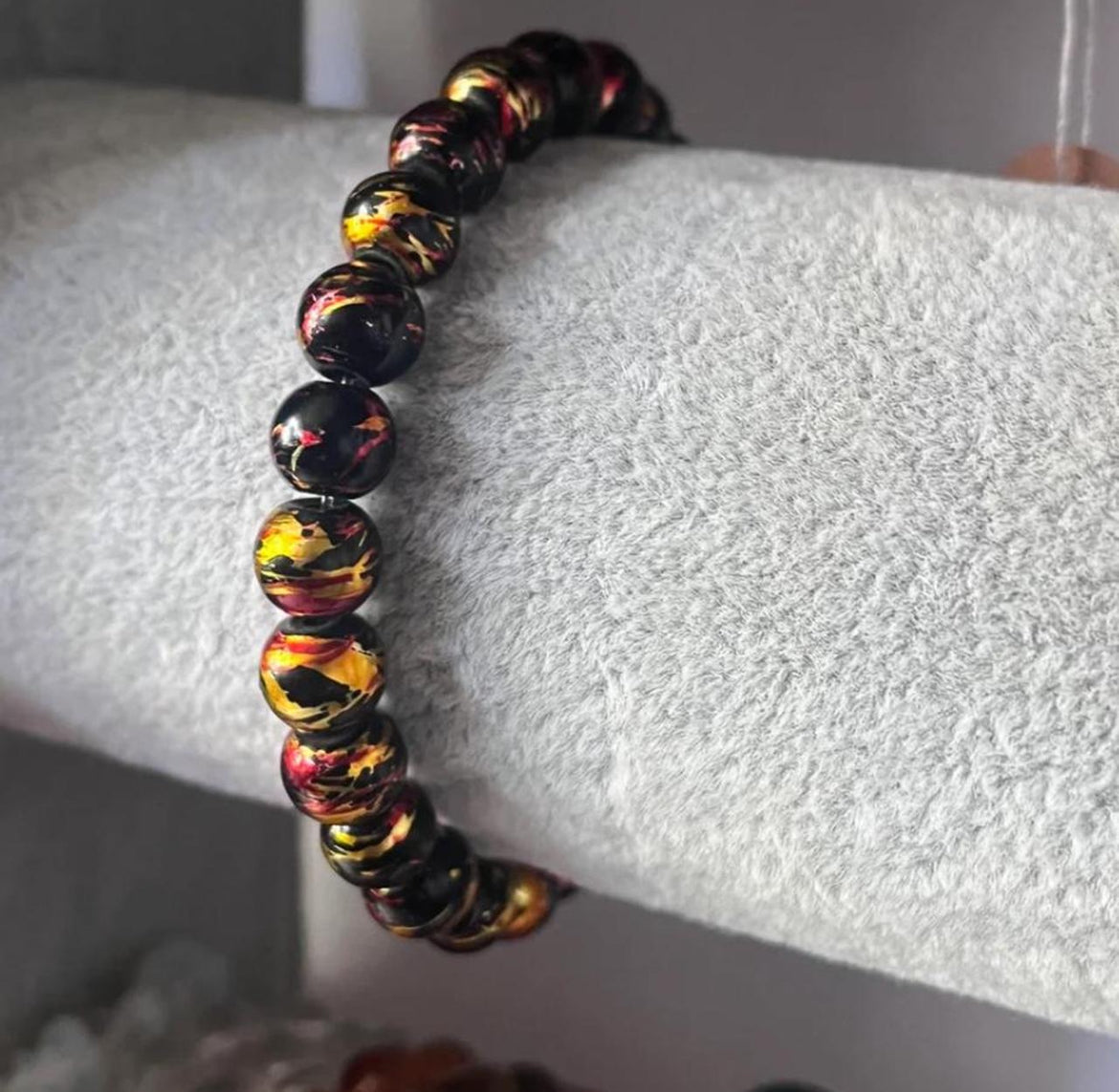 Black bracelet with gold and red accents